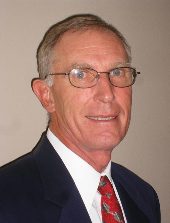 Man wearing a blue jacket with a logo in an indoor setting
